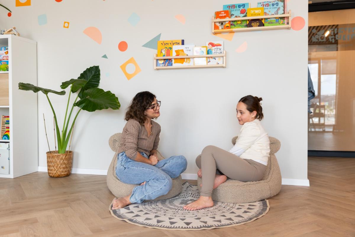 קבוצת ילדים משוחחת ומשחקת יחד באווירה תומכת ומעודדת